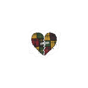May include: A sticker featuring a broken heart design. The heart is composed of patchwork squares in red, green, and yellow plaid patterns. The word "OUTSIDER" is printed across the break in the heart.
