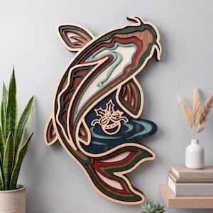 Könnte beinhalten: Ein mehrschichtiges Wandkunstobjekt aus Holz in Form eines Koi-Fisches mit komplizierten Ausschnitten in den Farben Dunkelrot, Waldgrün, Dunkelblau und Naturholztönen sowie einem zentralen Ausschnitt, der eine kleine Glocke mit Schleife zeigt.