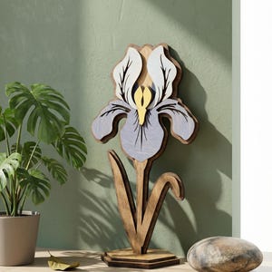 Peut inclure: Sculpture en bois représentant une fleur d'iris avec des tons bleu clair, blanc et jaune. La fleur est montée sur une tige et une base en bois. Objet décoratif pour la maison.