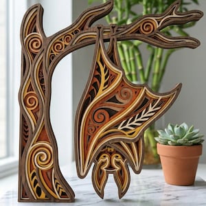 Peut inclure: Sculpture en bois multicouche représentant une chauve-souris suspendue à une branche, avec un tronc d'arbre comme base. La chauve-souris présente des motifs complexes dans des tons de marron, orange, jaune et blanc. Fond flou avec une plante en pot.