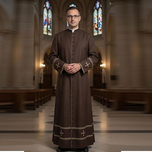 Może przedstawiać: Brązowa szata duchownego z białym kołnierzem i złotą haftowaną krzyżem na mankietach i obszyciu. Szata jest zapinana z przodu na guziki i jest noszona przez osobę w kościele.