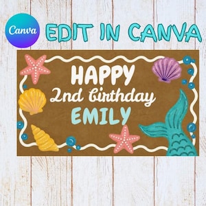 May include: A brown birthday sign with the text "HAPPY 2nd birthday EMILY" in white and light blue. The sign is decorated with starfish, seashells, and a mermaid tail. The words "EDIT IN CANVA" are at the top.