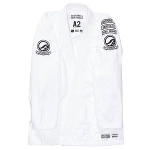 Könnte beinhalten: Ein weißer Kampfsportanzug, oder Gi, mit schwarzen gestickten Logos und Text. Der Gi trägt den Text "SHOYORO UNDEFEATED REBEL DIVISION" und die Größe "A2". Die Uniform hat einen traditionellen Kragen und ist aus strapazierfähigem Stoff gefertigt.