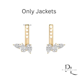 May include: A pair of gold earring jackets featuring three pear-cut clear stones arranged in a cluster at the base of a vertical bar with four circular post holes. The text "Only Jackets" and "PierceLab" are visible in the image.