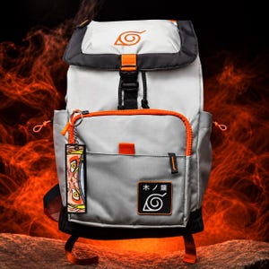 Pode incluir: Uma mochila cinza-claro com acabamento preto e detalhes em laranja brilhante. A aba superior exibe um símbolo de espiral laranja. Um bolso frontal inclui um emblema preto com o texto "木ノ葉" e um ícone de espiral, além de um chaveiro pendente.