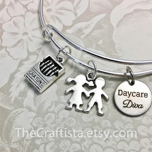 May include: Silver charm bracelet with three charms: a box of crayons, two children holding hands, and a round charm that says "Daycare Diva".