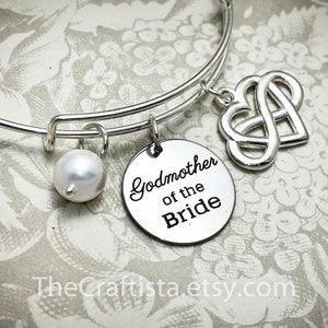 May include: Silver charm bracelet with a pearl, a heart-shaped infinity symbol charm, and a round charm that says "Godmother of the Bride".