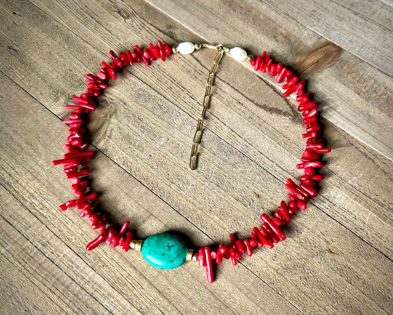 May include: A red coral necklace with a turquoise stone pendant and gold chain accents.