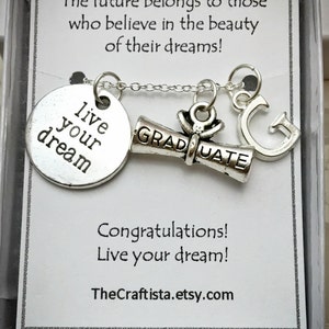 May include: A silver necklace with a charm that says "Live your dream" and a graduation cap charm. The necklace is in a white box with the text "The future belongs to those who believe in the beauty of their dreams! Congratulations! Live your dream! TheCraftista.etsy.com"