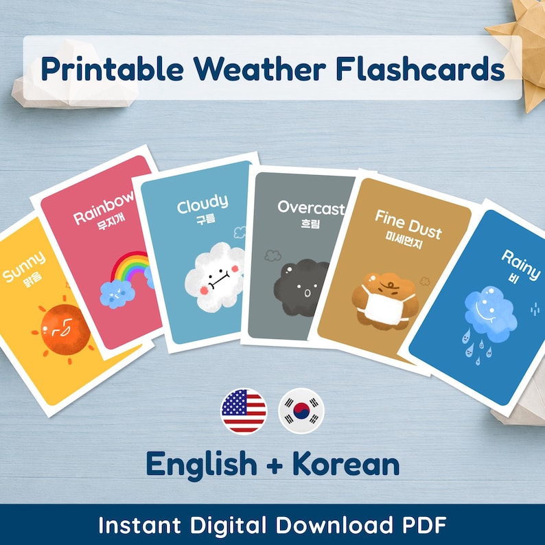 A set of printable weather flashcards featuring six visible cards spread across a light blue surface. The cards include 'Sunny' with a smiling sun, 'Rainbow' with a vibrant arc, 'Cloudy' with a cheerful white cloud, 'Overcast' with a dark gray cloud, 'Fine Dust' with a masked brown cloud, and 'Rain' with a blue crying cloud. Each card displays the weather term in both English and Korean. The image also states "Printable Weather Flashcards", "English + Korean" (with US and Korean flags)