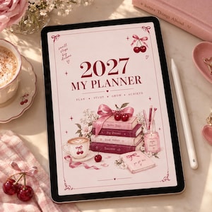 May include: A digital tablet displaying a 2027 planner cover with a cream background, red text, and illustrations of stacked books, a coffee cup, a candle, and cherries. The text reads 2027 MY PLANNER, small steps big dreams, PLAN STUDY GROW ACHIEVE, Better Days, Big Dreams, Good Habits, Success, and you got this.