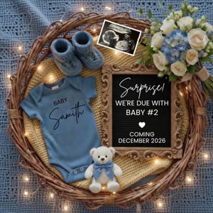 May include: A baby announcement with a blue onesie that says "Baby Samith", baby booties, a teddy bear, and a framed sign that says "Surprise! We're due with Baby #2 Coming December 2026". A bouquet of flowers and an ultrasound image are also included.
