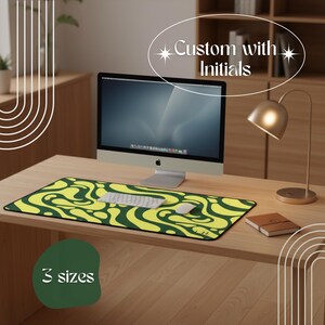 May include: A desk setup featuring a computer, keyboard, and mouse on a wooden desk. A large, rectangular mousepad with a yellow and green abstract design is in the foreground. Text on the image reads "Custom with Initials" and "3 sizes".