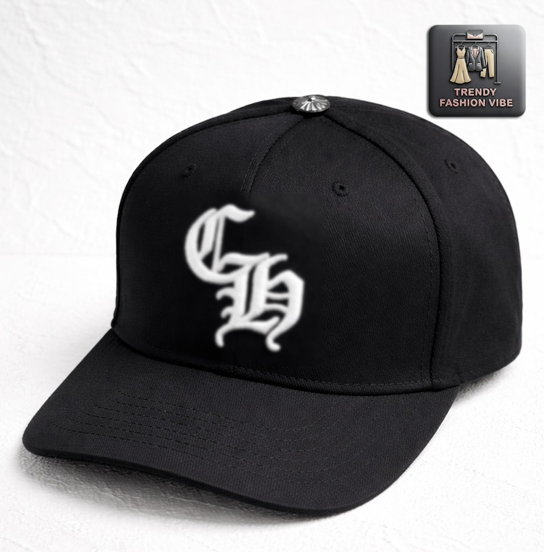 May include: Black baseball cap with a curved brim and a white embroidered design on the front. The cap features a silver button on top and a Trendy Fashion Vibe logo.
