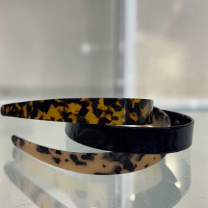 Può includere: Un set di tre tazze in ceramica con finitura opaca e macchiettata. Le tazze sono nei toni del crema, grigio chiaro e grigio scuro. Ogni tazza ha un design semplice e minimalista.