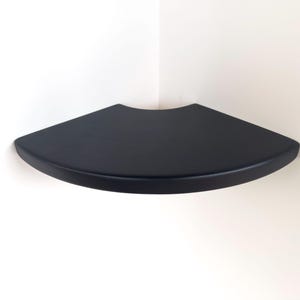 May include: A white ceramic mug with a black handle and the text "But First, Coffee" in a black, bold font. The mug is on a white surface.