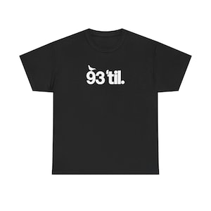 May include: A black short-sleeve t-shirt featuring white text that reads 93 'til. with a small white silhouette of a pigeon perched on top of the number 9. The design is centered on the chest of the garment, which has a crew neckline.