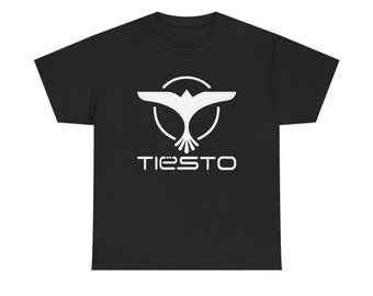 May include: A black short-sleeved t-shirt featuring a white graphic print on the chest. The design consists of a stylized bird silhouette enclosed within a circle, positioned above the text TIESTO in a modern, sans-serif font style.