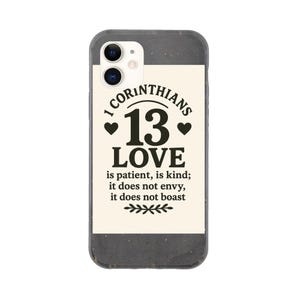 May include: A smartphone case with a black and cream design. The case features the text "1 Corinthians 13 LOVE" in black, along with the full verse. The case has a dark grey border.