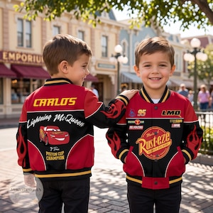 May include: A red and black varsity-style jacket featuring Lightning McQueen graphics, the name Carlos, and Rust-eze branding. The jacket includes flame patterns on the sleeves, the number 95, and text reading 7 Time Piston Cup Champion.