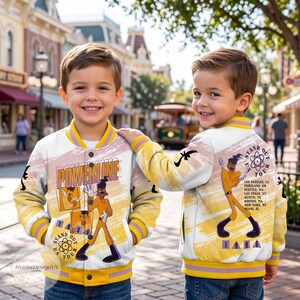 May include: A white and yellow varsity jacket featuring a graphic of the character Powerline. The front displays the text Powerline and Stand Out Tour 1996. The back shows Powerline with a list of tour cities and the text Stand Out Tour 1996.