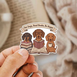 May include: A sticker featuring three dachshunds. One dog is reading a stack of books, another is reading a book with glasses, and the third is holding a coffee cup. The banner above reads "Pet Dogs, Read Books, Be Happy."
