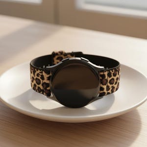 Peut inclure: Une tasse en céramique blanche avec une anse noire et le texte "But First, Coffee" en noir, dans une police manuscrite. La tasse est posée sur une surface blanche.