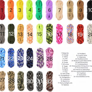 May include: A collection of thirty-two coiled paracord bundles arranged in rows, each labeled with a number from 1 to 32. The cords feature various solid colors and multi-colored patterns, including red, orange, yellow, lime, green, purple, black, gray, and camouflage.