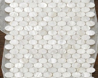 Mosaico ovalado blanco de nácar, protector contra salpicaduras de conchas montado sobre malla, elegante decoración de pared elíptica.