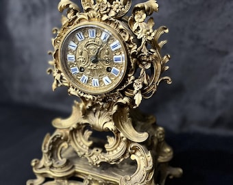 Reloj de repisa rococó francés antiguo de bronce. Reloj de mesa con volutas ornamentadas. Pieza decorativa de cuerda.