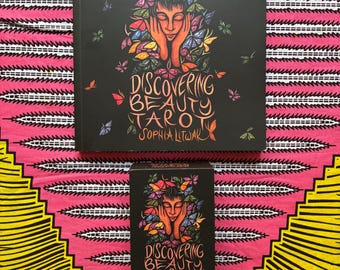 May include: A square book and a rectangular deck box featuring the title Discovering Beauty Tarot by Sophia Litwak. Both items have a black background with a central illustration of a person with hands on their face surrounded by colorful butterflies.