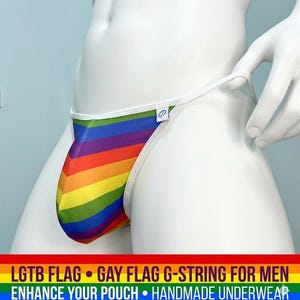 May include: A rainbow-striped G-string underwear with a white trim. The underwear features a pouch design and is displayed on a mannequin. The text at the bottom reads "LGTB FLAG • GAY FLAG G-STRING FOR MEN • ENHANCE YOUR POUCH • HANDMADE UNDERWEAR."