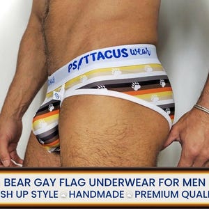 May include: Underwear with a bear flag design. The underwear features stripes in brown, orange, yellow, and white, with bear paw prints. The waistband is white with the text "PSITTACUS wear" in blue.