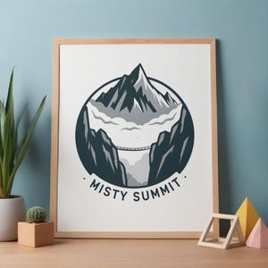 Puede incluir: Un estampado enmarcado con un diseño de paisaje de montaña. La obra de arte representa un pico montañoso, un puente y el texto "Misty Summit" en un diseño circular. La paleta de colores incluye tonos de gris, blanco y verde azulado. El marco es de madera clara.