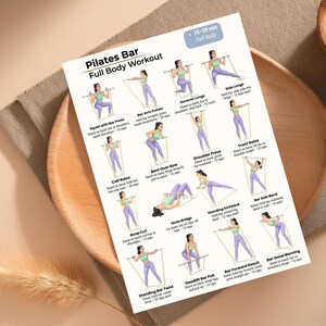 May include: A Pilates Bar Full Body Workout guide with illustrations of various exercises. The exercises include squats, lunges, rows, and presses, with instructions for each. The guide is on a white paper with a wooden plate in the background.