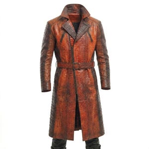 May include: A full-length, brown and orange leather trench coat with a crocodile skin texture. The coat features a notched collar, a belt at the waist, and a zipper closure. The sleeves and lower portion of the coat are a darker shade of brown.