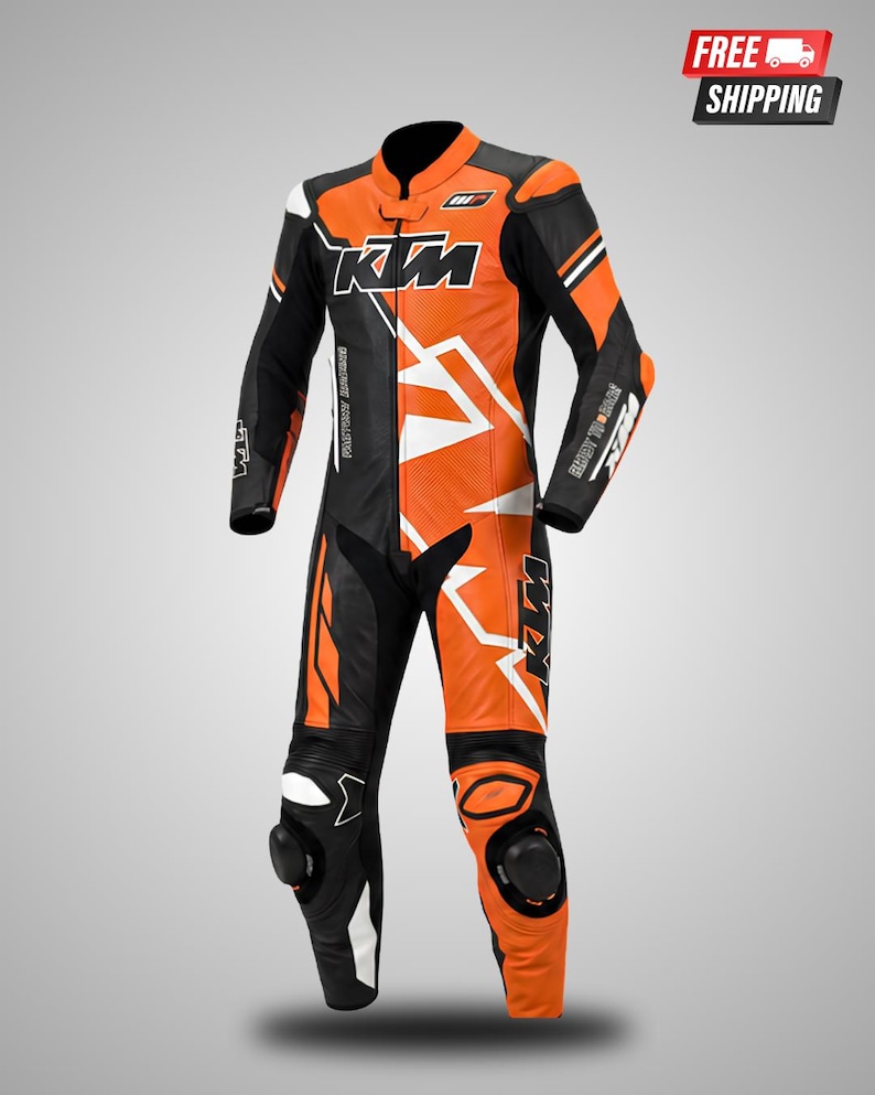May include: A one-piece motorcycle racing suit in black, orange, and white. The suit features the KTM logo on the chest, sleeves, and legs, with integrated black knee protectors, a mandarin collar, and perforated leather panels on the torso.