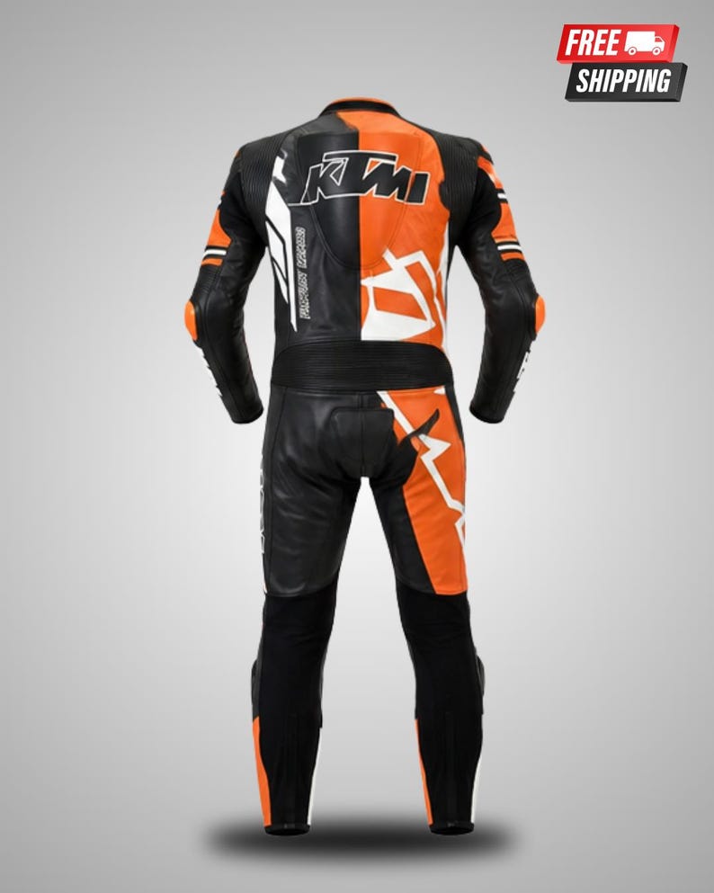 May include: A black and orange motorcycle racing suit featuring the text KTM on the upper back. The suit is constructed with leather panels, integrated protective padding at the elbows and knees, and a split color design across the torso and legs.