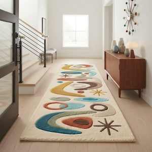 May include: A long rectangular area rug with a cream-colored background featuring a repeating pattern of abstract shapes in shades of teal, mustard yellow, rust orange, brown, and sage green, including circles, boomerangs, and starbursts.