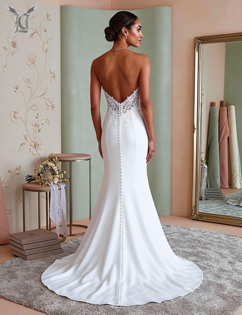 Back view of minimalist satin mermaid bridal gown featuring strapless design, sleek fitted silhouette, elegant train, and timeless modern wedding style.