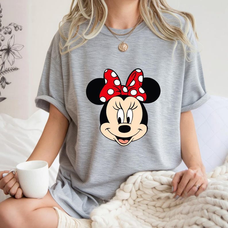 Op de afbeelding: Een witte keramische mok met een zwarte handgreep en de tekst "But First, Coffee" in een vetgedrukte, zwarte letter. De mok staat tegen een vage achtergrond, wat een gezellige setting suggereert.