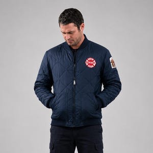 Peut inclure: Un blouson bomber matelassé bleu marine avec fermeture éclair frontale, col et poignets côtelés. La poitrine gauche présente un écusson circulaire rouge et blanc du Chicago Fire Department, et un emblème rectangulaire sur la manche gauche.