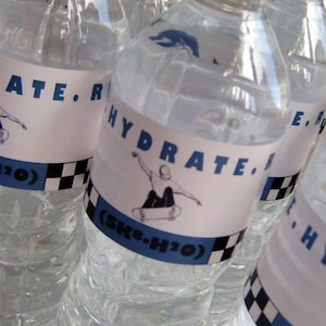 Puede incluir: Un grupo de botellas de agua de pl&aacute;stico transparente con etiquetas que dicen "HYDRATE. (SK8.H2O)" y presentan un dibujo animado de un patinador. Las etiquetas tambi&eacute;n tienen un patr&oacute;n de cuadros en blanco y negro.
