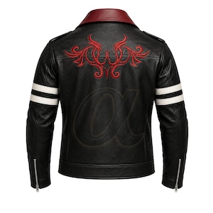 Puede incluir: Una chaqueta de cuero negra con cuello rojo oscuro, bordado tribal rojo en la parte superior de la espalda y dos rayas blancas horizontales en cada manga. Los puños tienen cremalleras metálicas plateadas y la espalda muestra una marca de agua.