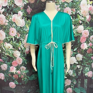 May include: A long, teal blue, satin robe with a zipper closure and a drawstring waist. The robe has short, wide sleeves with white trim.