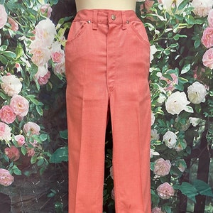 May include: A pair of light pink, high-waisted, wide-leg pants.