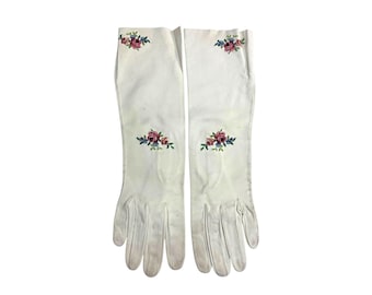 May include: A pair of white long gloves with embroidered floral designs in pink, blue, and green.