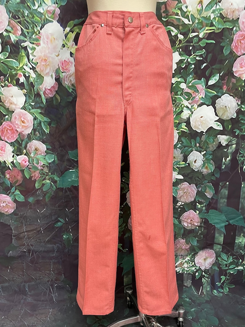 May include: A pair of light pink, high-waisted, wide-leg pants.