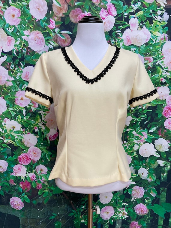 cream blouse with black trim