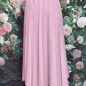 May include: A light purple pleated skirt with a straight hemline. The skirt is made of a smooth, lightweight fabric.